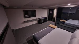 a small room with a bed and a tv at Real La Viga Motel in Mexico City