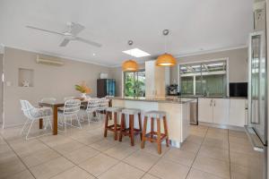 a kitchen and dining room with a table and chairs at Noosa Sunrise - Pet-friendly with Pool in Sunrise Beach