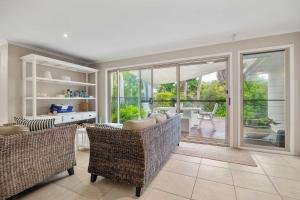 a living room with two couches and a patio at Noosa Sunrise - Pet-friendly with Pool in Sunrise Beach