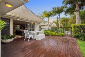 a deck with a table and chairs on a house at Noosa Sunrise - Pet-friendly with Pool in Sunrise Beach
