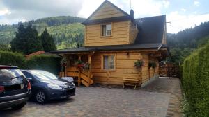 a wooden cabin with a car parked in front of it at Świerkowa Chata in Szczyrk