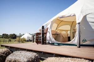 a large tent with a wooden deck in a field at Bukirk Glamping & Luxury Cabins - Clare Valley in Clare