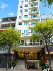 a large white building with trees in front of it at Bon Ami Hotel - Thiên Xuân in Ho Chi Minh City
