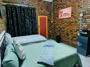 a room with two beds and a brick wall at Acasa do Delco Accommodatiion in Welkom