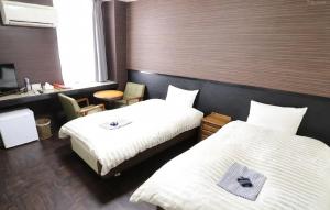 a hotel room with two beds and a desk at 水戸第一ホテル本館 in Mito