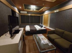a small room with a bed and a couch at Hotel WIN in Fukaya +8 photos