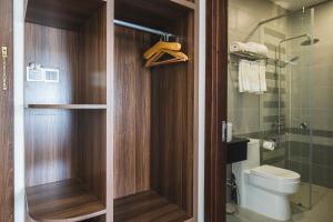 a bathroom with a toilet and a glass shower at City Center Rosa Hotel in Phú Quốc +40 photos
