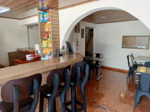a bar in a restaurant with chairs and a counter at Hotel Antonela Amorim in Barrio Centenario