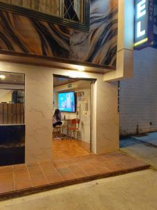 a person sitting at a table in a room at Hotel Antonela Amorim in Barrio Centenario