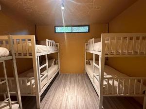 a room with three bunk beds and a window at The Breeze Hostel in Haad Rin