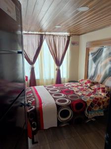 a bedroom with a bed and a window with curtains at Hotel Antonela Amorim in Barrio Centenario