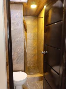 a small bathroom with a toilet and a shower at Hotel Antonela Amorim in Barrio Centenario +22 photos