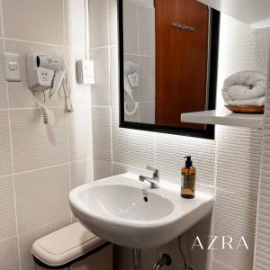 a white bathroom with a sink and a mirror at Zara at Mesavirre Bacolod in Bacolod