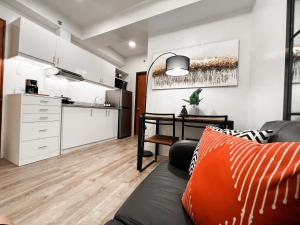 a living room with a couch and a kitchen at Zara at Mesavirre Bacolod in Bacolod