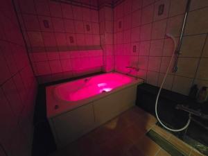 a pink bath tub with a pink light in a bathroom at Hotel WIN in Fukaya