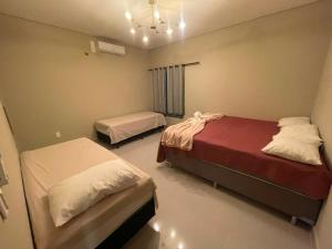a bedroom with two beds and a chandelier at Pousada Recanto do Oásis in Triunfo