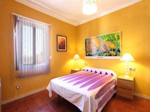 カネット・デ・マールにあるBeach Apartment Santissimaのベッドルーム1室(ベッド1台付)が備わります。壁には絵画が飾られています。