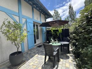 a table and chairs with an umbrella on a patio at Vent d'ouest in Messanges