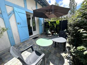 a patio with a table and chairs and an umbrella at Vent d'ouest in Messanges