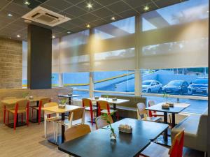 a restaurant with tables and chairs and a large window at ibis Manaus Aeroporto in Manaus