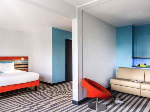 a bedroom with a bed and a red chair at ibis Styles Antony Paris Sud in Antony +75 photos