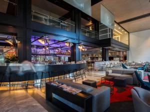 a bar with couches and chairs in a restaurant at Pullman Sydney Airport in Sydney
