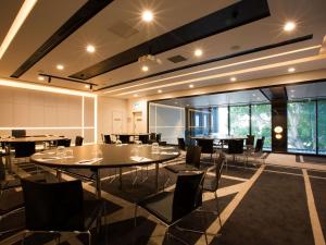 a dining room with tables and chairs and windows at Pullman Sydney Airport in Sydney