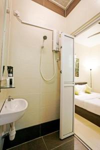 a bathroom with a shower and a sink and a bed at Swing & Pillows - Golden Lodge Tanah Rata, Cameron Highland in Tanah Rata +156 photos