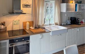 a kitchen with a sink and a counter top at 3 Bedroom Nice Home In Os in Oma