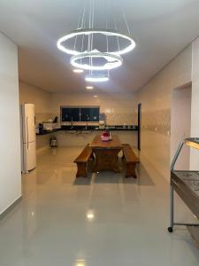 a large kitchen with a table and a large chandelier at Pousada Recanto do Oásis in Triunfo