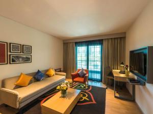 a living room with a couch and a table at Grand Mercure Mysore - An Accor Brand in Mysore