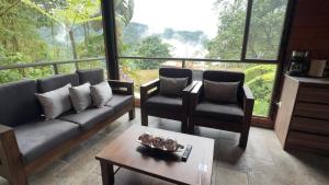 a living room with a couch and two chairs and a table at SAMAY FOREST- MASHPI AMAGUSa in Mashpi