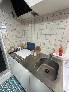 a kitchen counter with a stainless steel sink at Panda Home Umeda 01 in Osaka +7 photos