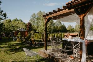 a woman sitting in a hot tub in a backyard at STACJA RUDA in Złota Wieś +91 photos