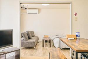 a living room with a couch and a bed at Bird Heights 101 in Furano