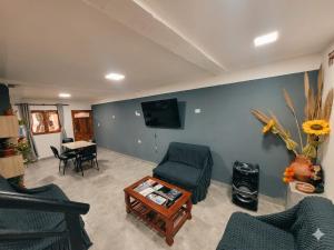 a living room with chairs and a tv and a table at La Tía Rola in Humahuaca