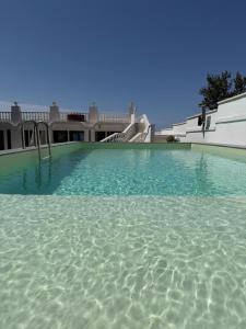 a large swimming pool in front of a house at Villa Blanca del mar in Quartu SantʼElena