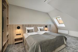 a bedroom with a large bed and a skylight at Hotel Zator in Zator