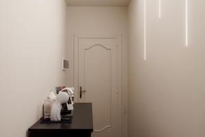 a room with a white door and a coffee maker on a table at La Mora Rooms in Linguaglossa