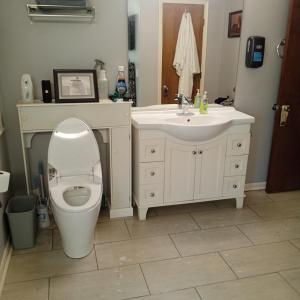 a white bathroom with a toilet and a sink at Cws seperate entrance in Omaha +15 photos
