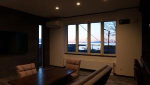 a dining room with a table and a large window at Sugi Nest Rausu-villa- in Rausu