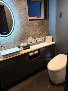 a bathroom with a toilet and a sink and a mirror at Sugi Nest Rausu-villa- in Rausu +5 photos