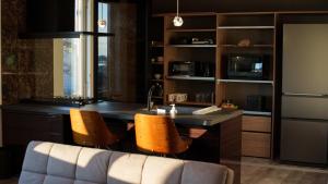 a kitchen with a counter with two chairs and a sink at Sugi Nest Rausu-villa- in Rausu