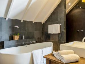 a bathroom with a bath tub and a sink at Santa Teresa Hotel Rio de Janeiro - MGallery Collection in Rio de Janeiro