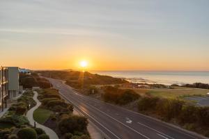 an empty road with the sunset in the background at Wyndham Resort Torquay in Torquay