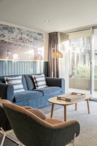 a living room with two blue couches and a table at Wyndham Resort Torquay in Torquay
