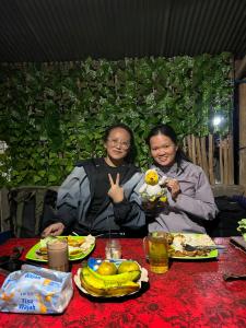 two women sitting at a table with aitatingitatingitatingitatingitatingitatingitatingitating at Batur Sunrise Tent in Kubupenlokan