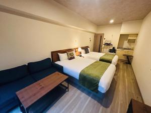 a hotel room with two beds and a couch at goom Hotel Nakasu in Fukuoka +30 photos