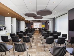 a conference room with chairs and a projection screen at ibis Sens in Sens