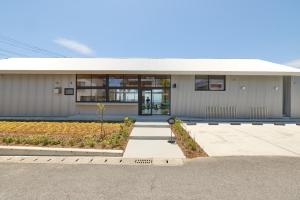 a large white building with a large window at DEAR MOM - Hotel & Cafe in Onjuku